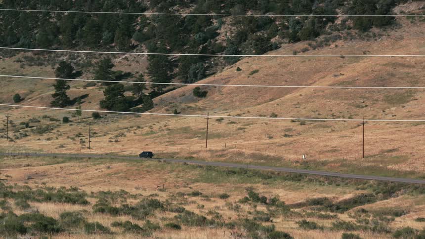 The view is of cars driving down the street by the desert area