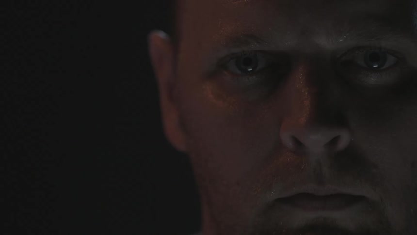A man blinks as light flickers on his face