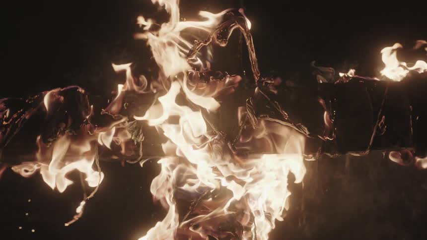 A cross is on fire at night