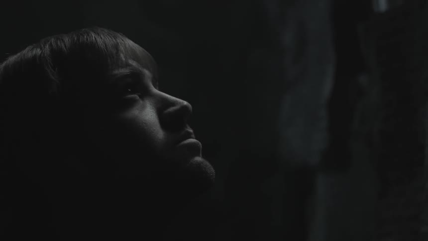 A man looks up in a dark area