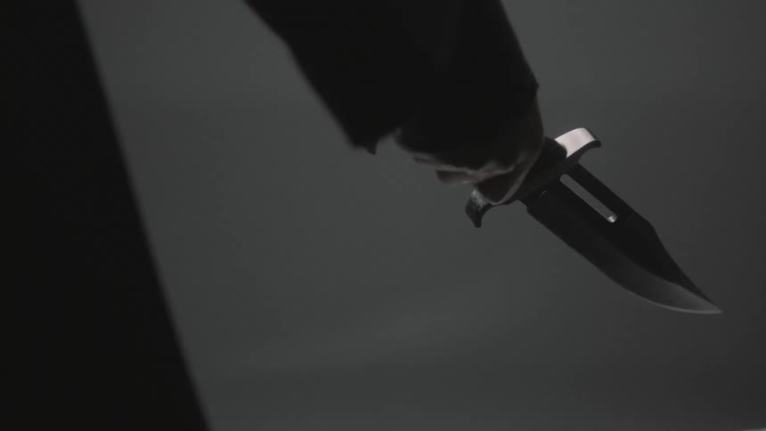 A person raises a knife