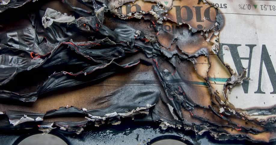 Smoke rises from a newspaper that was set on fire