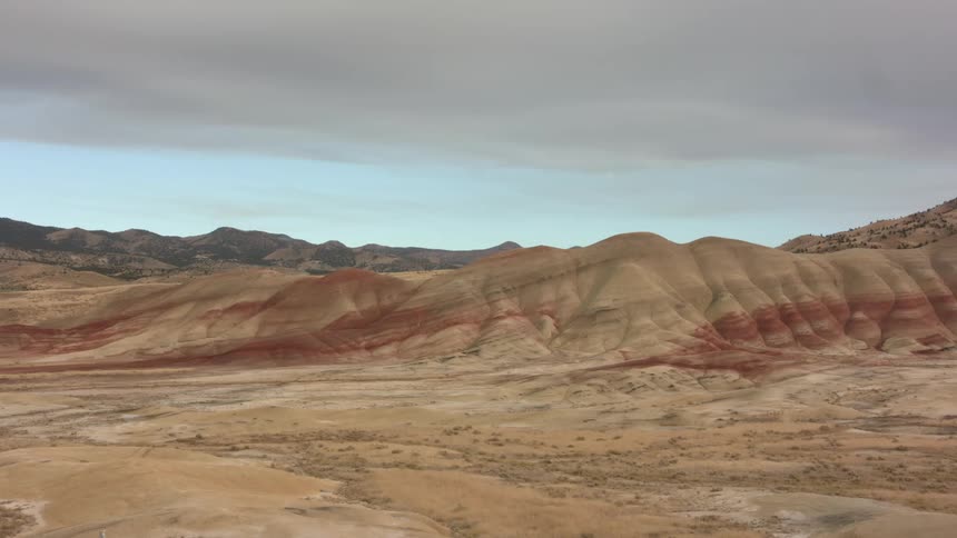 Blue sky shows between dense cloud cover and desert hills