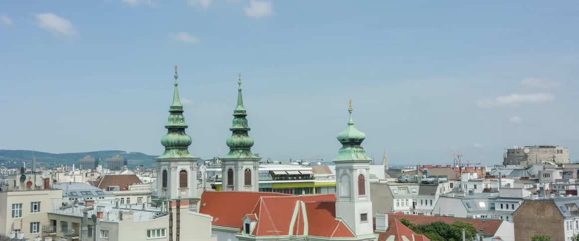 Green spires on top the church of mariahilf in vienna under a blue sky