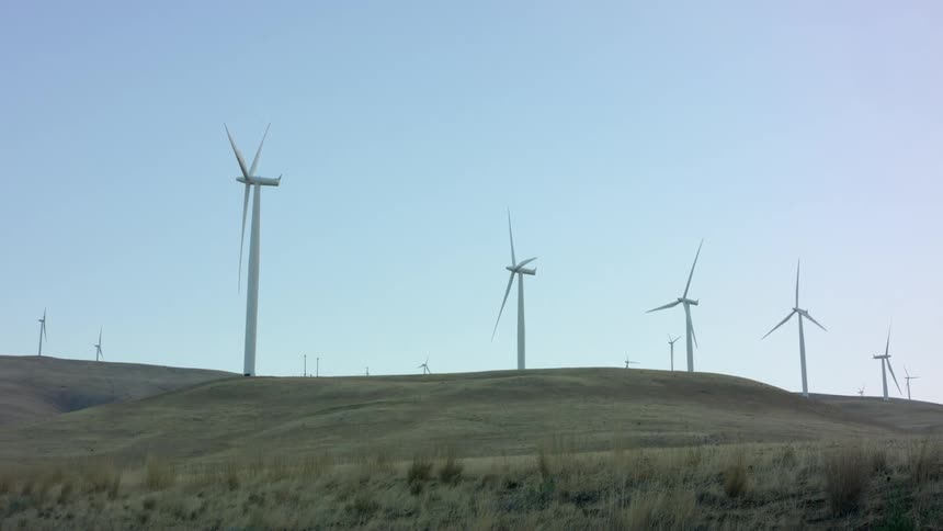 Wind mills are displayed in an open field