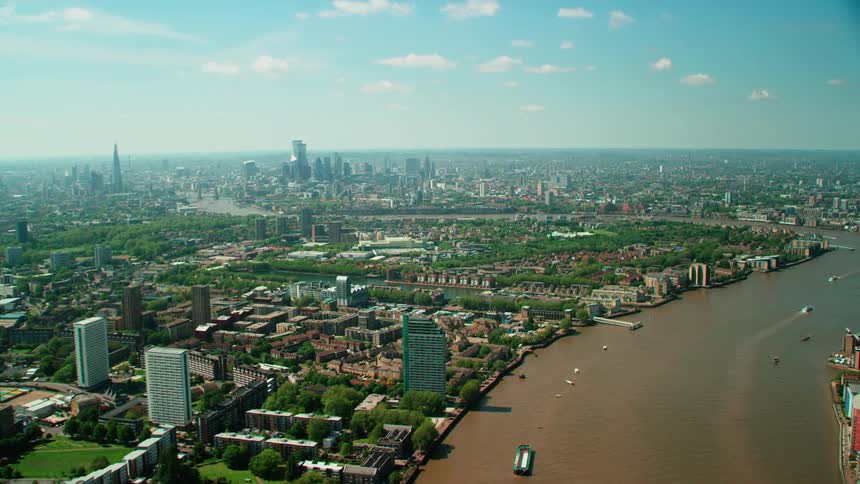 Aerial view of a large city suburbs and river displaying buildings and boats