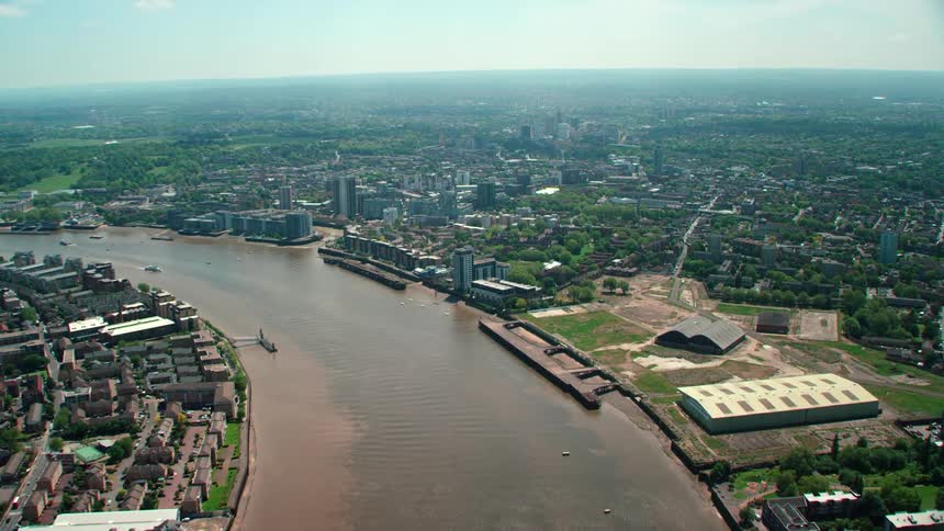 Aerial view of a muddy river flowing through a small town in the plains at daytime