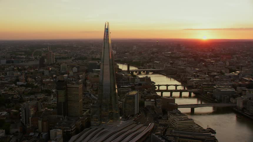 Aerial view of a city and sunset on the horizon with a tall building