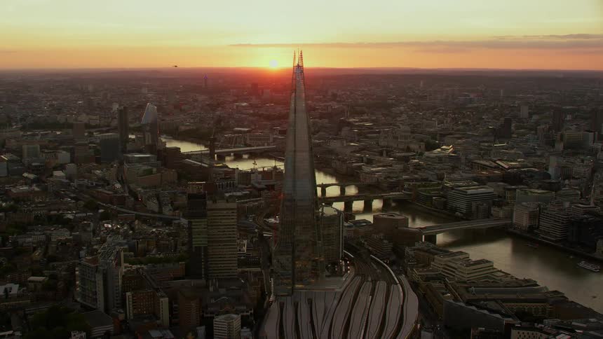 Aerial view of the shard skyscraper and buildings next to river thames at sunset in london