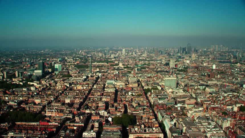 Orbiting aerial view of a city under a bright blue sky