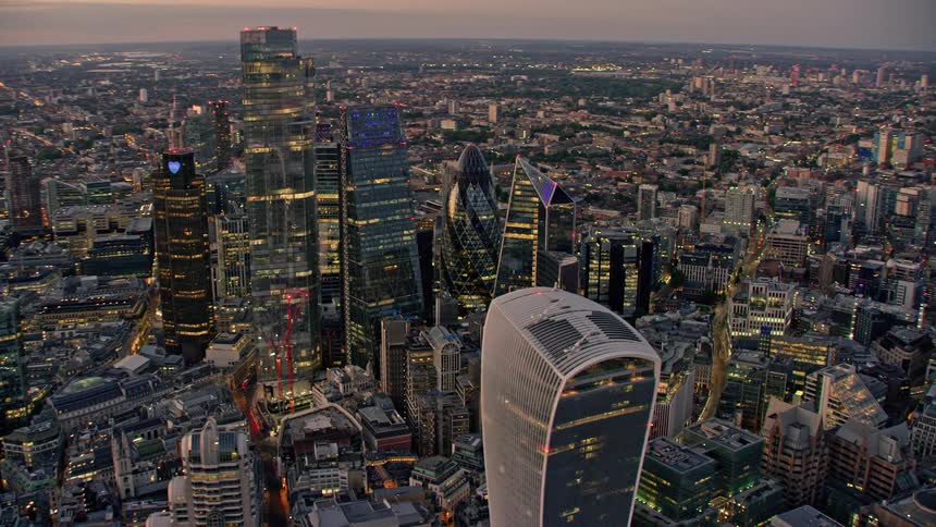 An aerial view of a city with large buildings with elegant architecture and the city skyline in the background