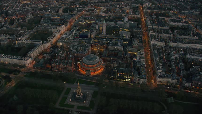 Lit domed building sits across highway from tower as heavy traffic moves along busy streets