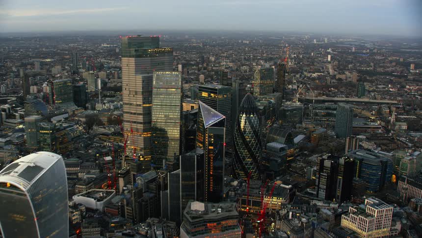 Boats move through river as construction cranes work on skyscrapers nearby