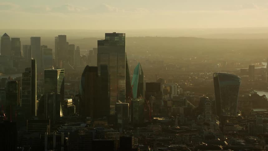 Orbiting aerial view of the tall skyscrapers on london downtown at evening