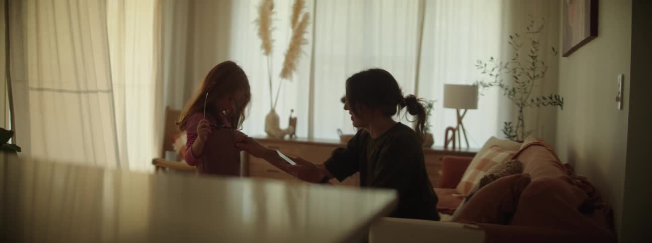 A girl tries on sunglasses to show her mother
