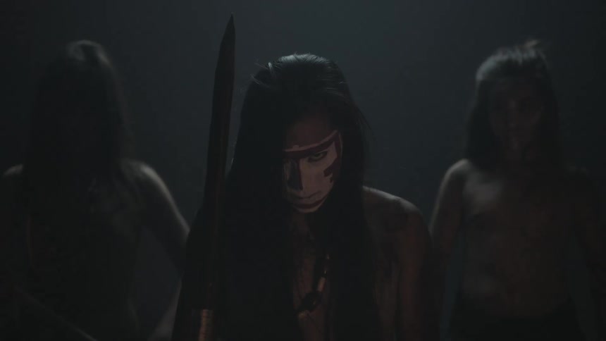 Three people are standing in a very dark area