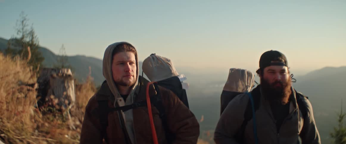 Two men hiking up a mountain carrying backpacks