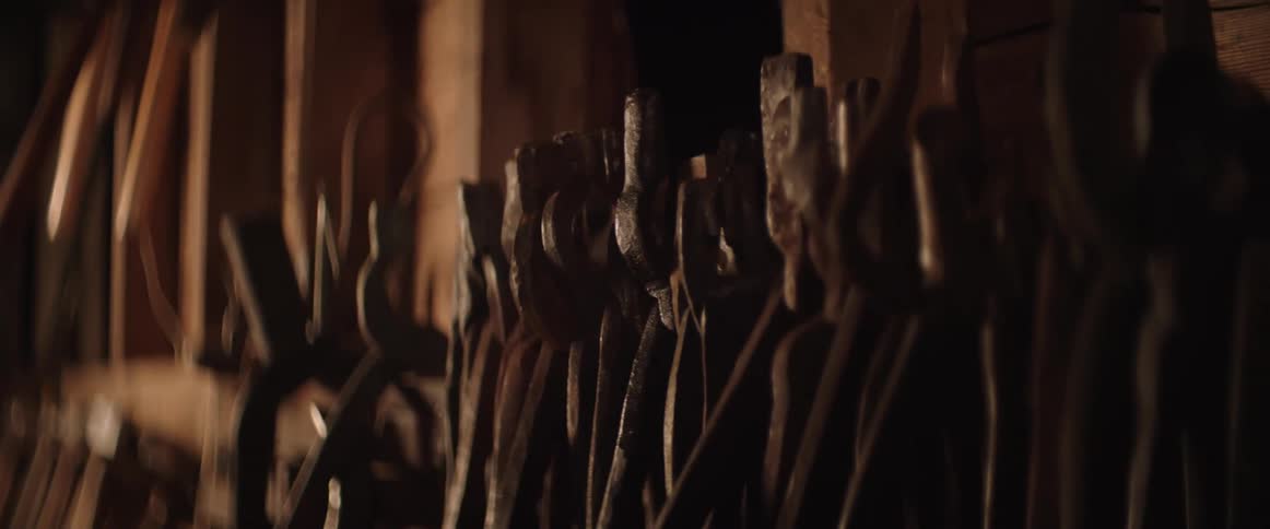 Many pliers hang on the wall of a blacksmith workshop