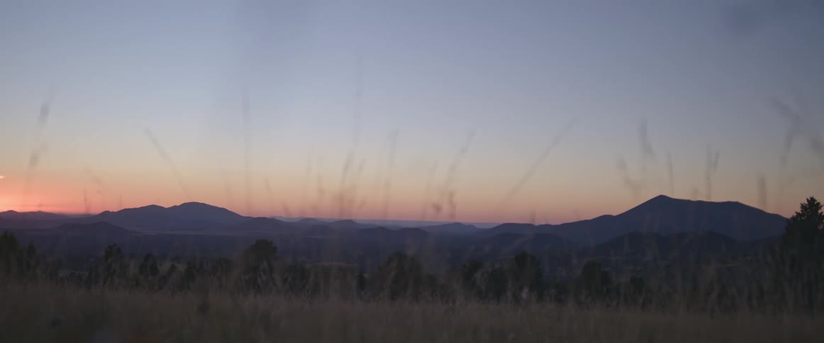 The sun is setting on the mountains