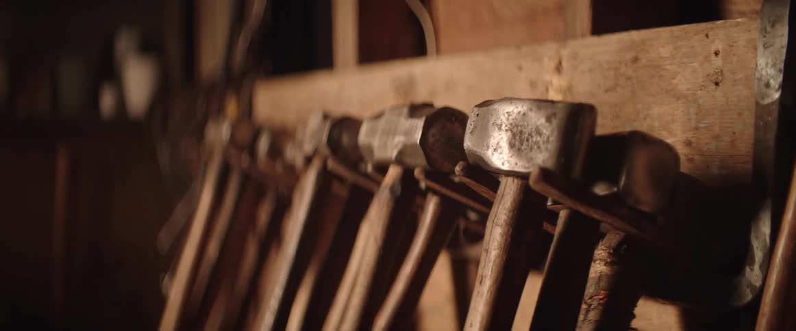 Several hammers hang on board in workshop