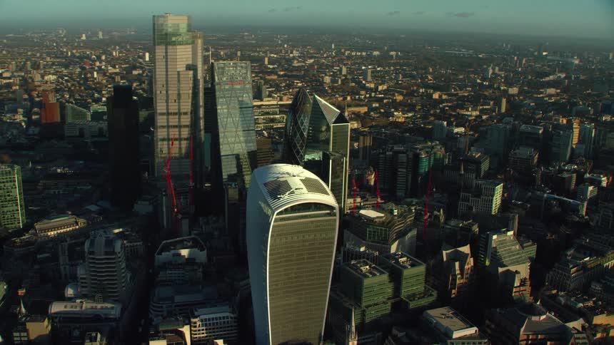 Orbiting aerial view of the tall skyscrapers on london skyline at evening