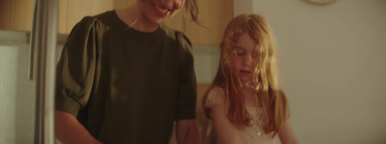 Mother and daughter kneading dough over the kitchen counter at home