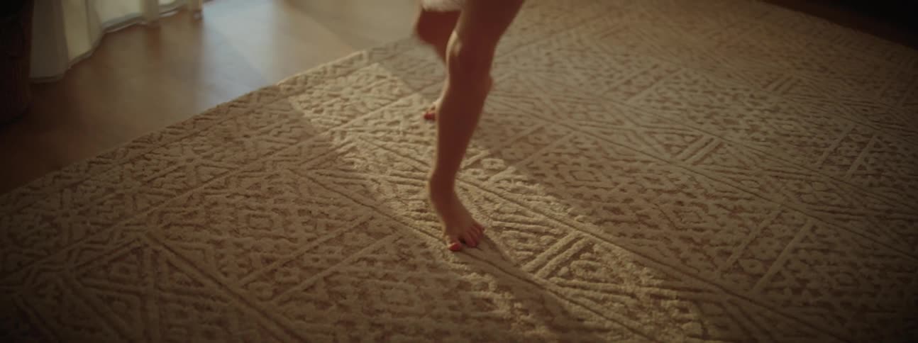 Ballerina in a tutu performs ballet on rug in living room at home