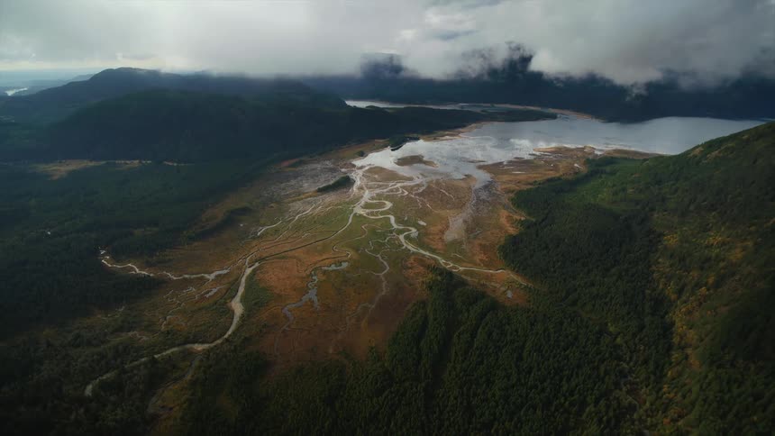 Aerial view of rivers branching from a lake in the remote wilderness with low hanging clouds