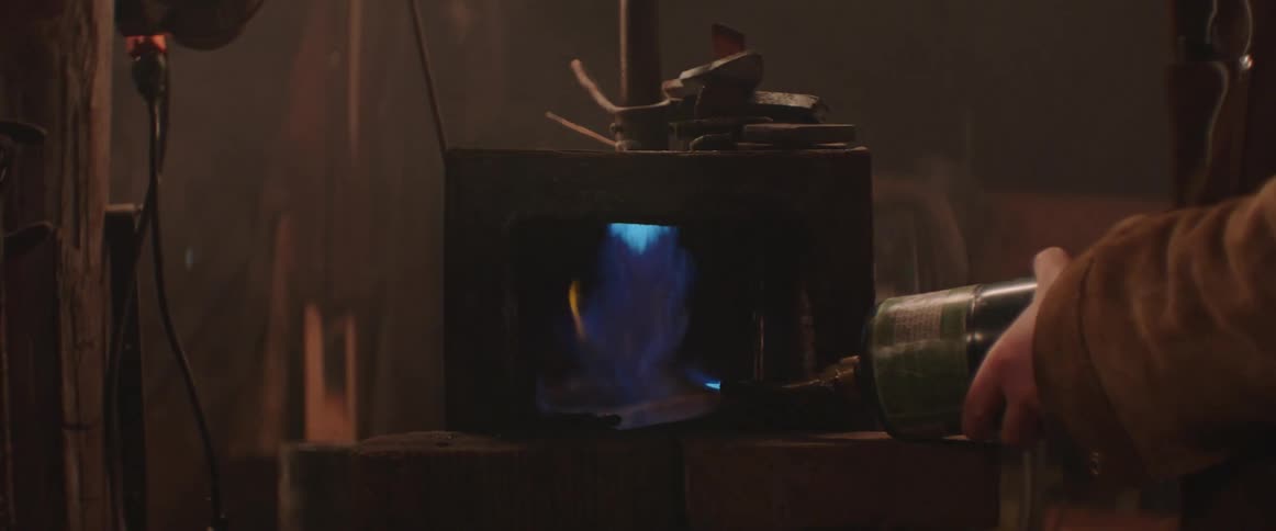 A fireball bursts to life as a person lights a blacksmith forge