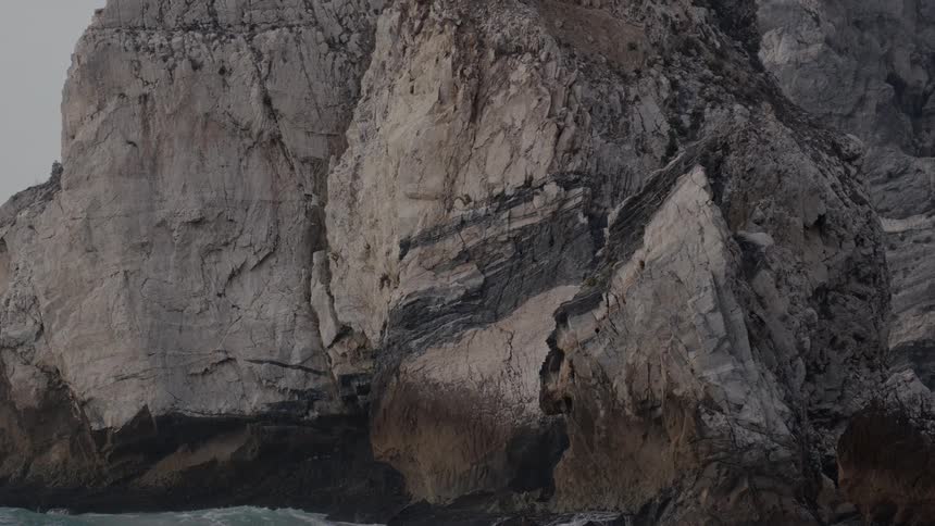 Waves crash against the rocks of a shore