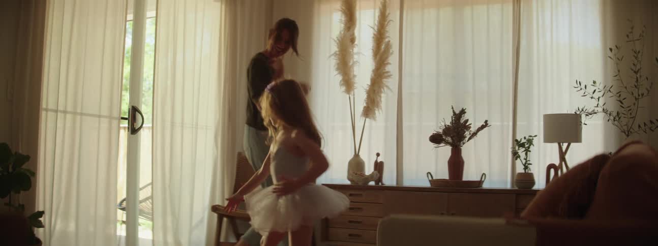 A mother and daughter in the living room dancing