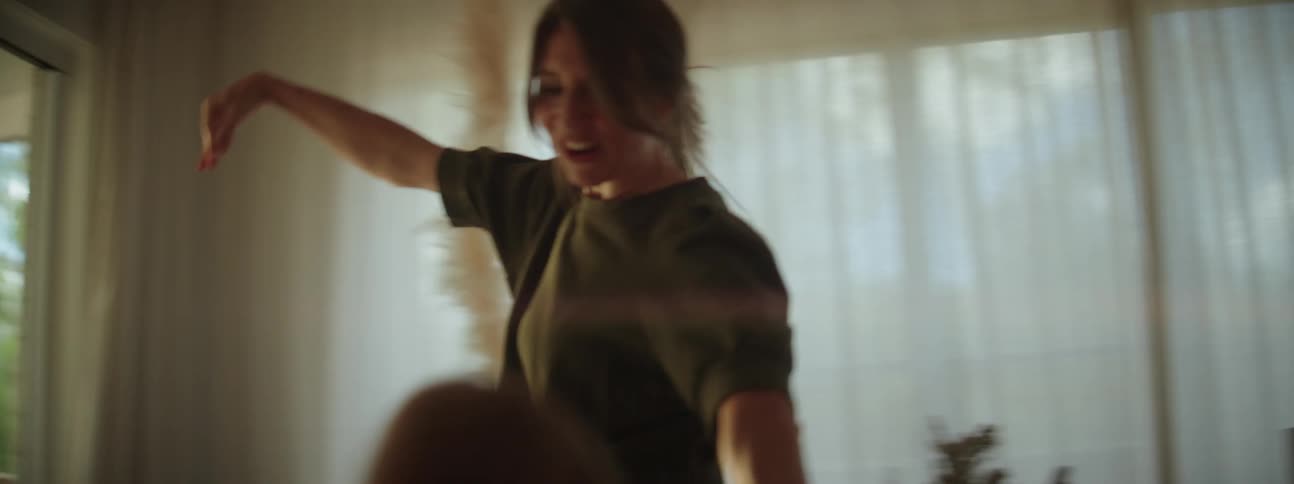 Mother holding daughters hands while dancing and smiling