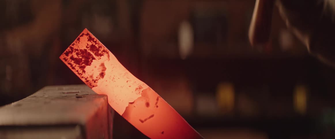 A man pounds hot steel with a hammer