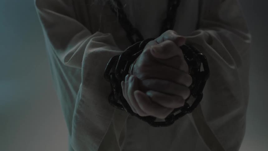 Person with chains around their wrists