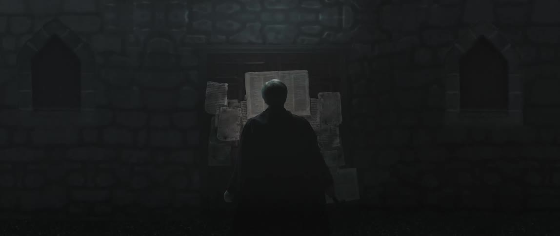 A man looks at papers nailed to a board