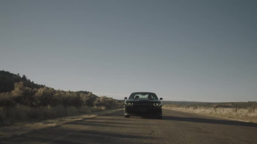 A car races down a road on a sunny day