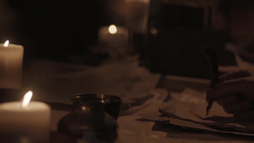A man dips a quill in ink and begins to write