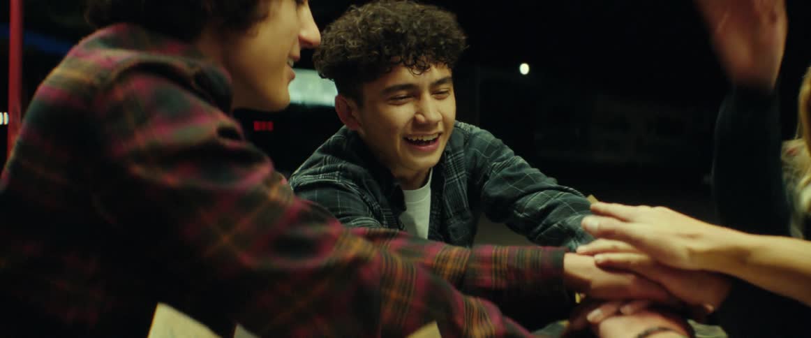 Four teens playing a game outside of a diner