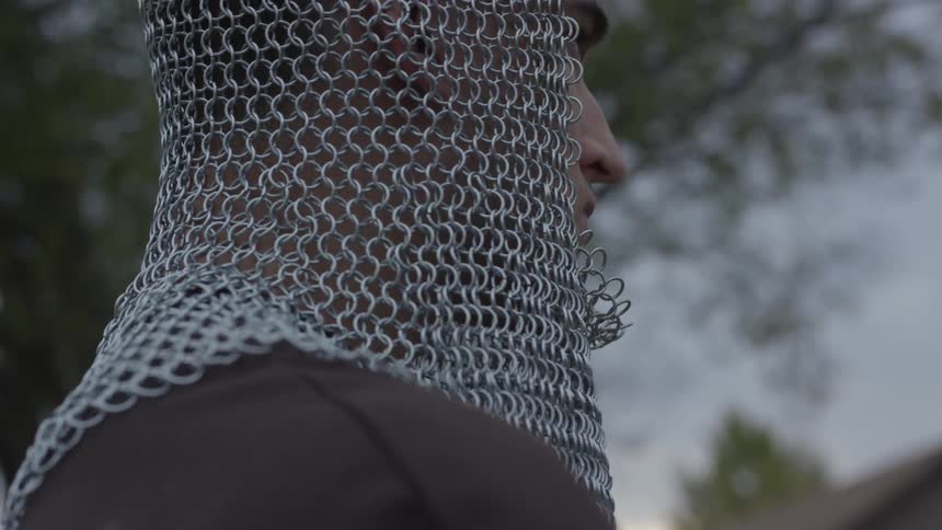 A man with a chain headpiece raises his head