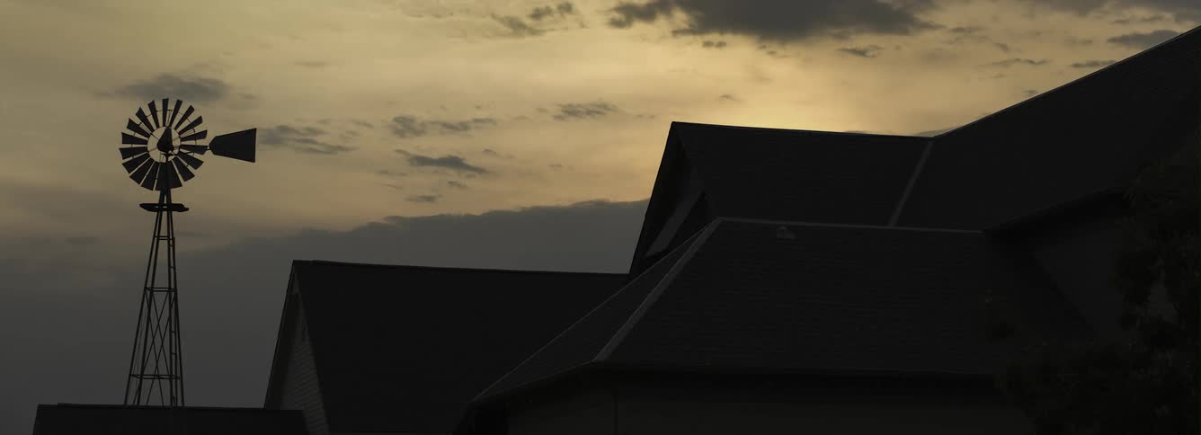 Clouds move over a rural home at dusk