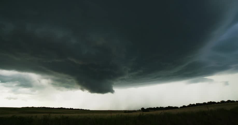 Lightning strikes as dark clouds move over a field