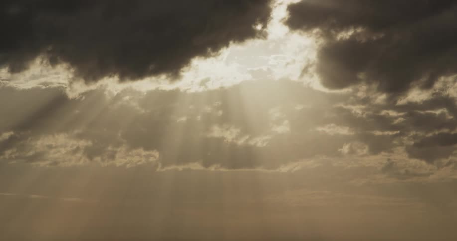 Sunlight shining through clouds casting sunrays through the sky