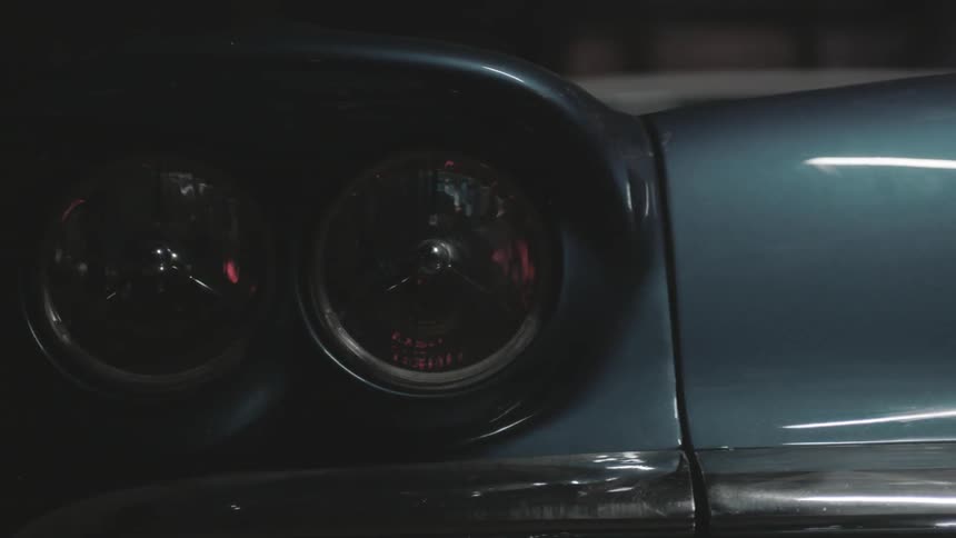 The headlights of an old car are turned on
