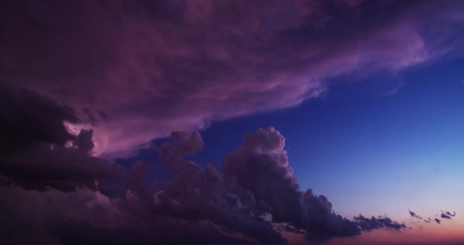 Dark clouds float and gather in the sky and lightnings flash