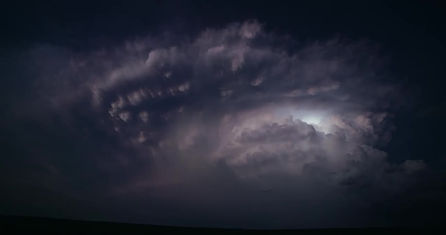 Lightning flashing in storm clouds at night