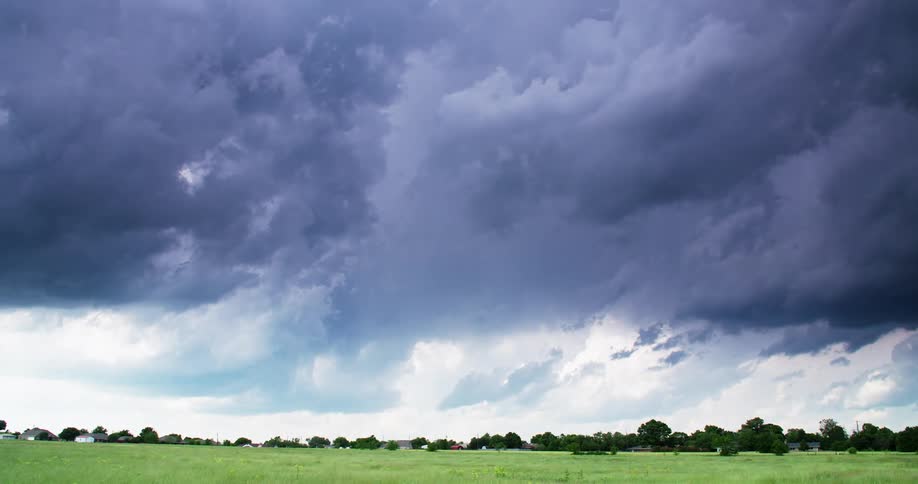 Thick clouds pass over a grassland during the day
