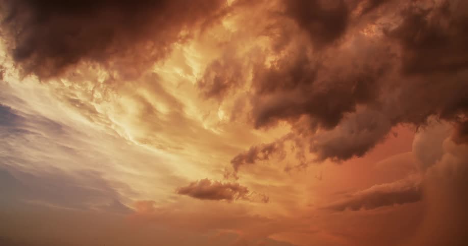 Clouds float in red sky and lightning flashes