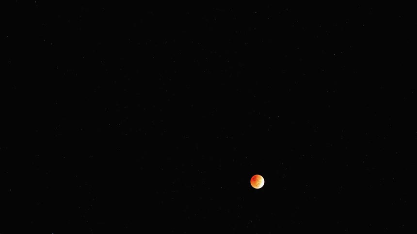 The full moon is glowing as it moves down in the night sky