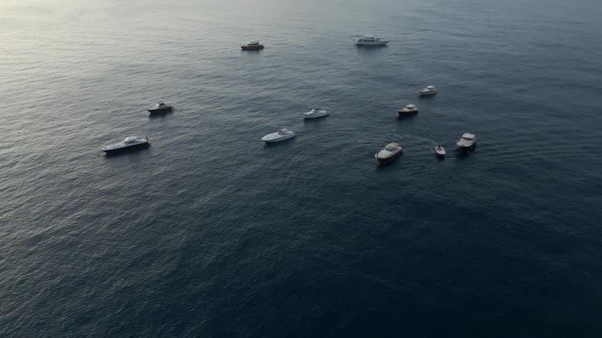 A small group of boats are sitting in the middle of the ocean
