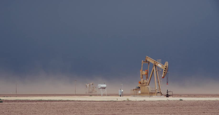 A pumpjack operates at an oil well in the desert